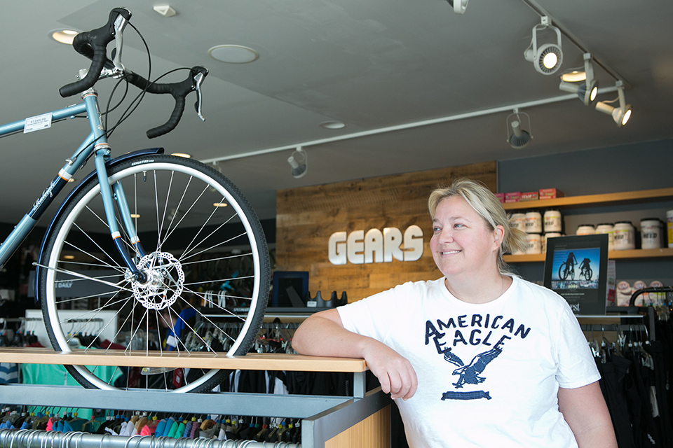 Co-owner, Ira Kargel, standing in front of a bicycle display in Gears bike shop, which has been brightened up with LED lights.