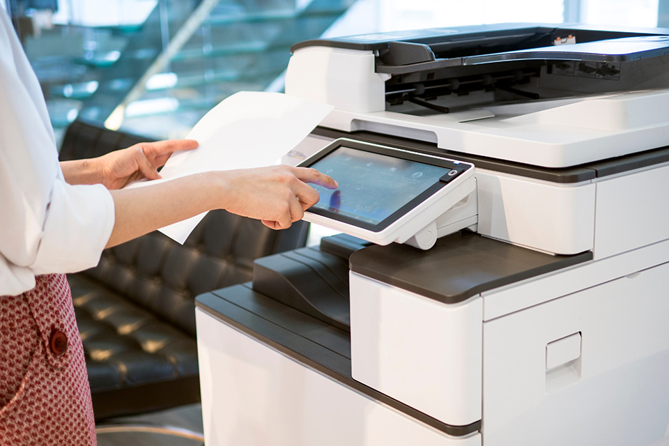 employee using modern office printer to email a document