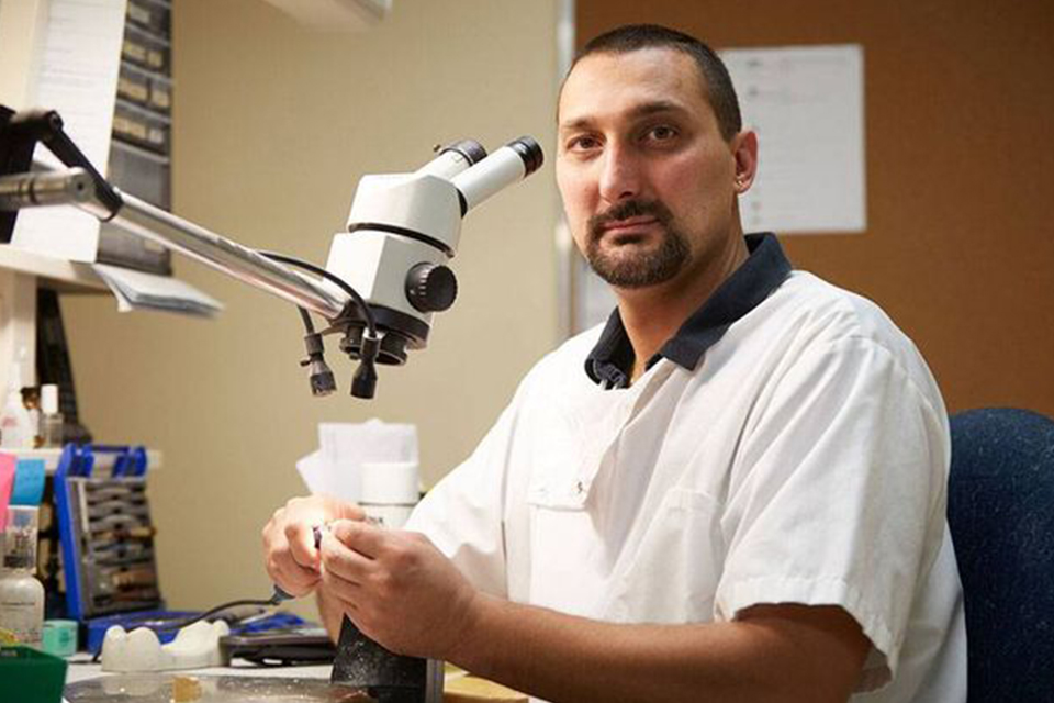 Slavko Ljubinkovic working behind a microscope at Weber Dental Lab