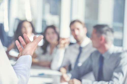 man presenting to colleagues in meeting room